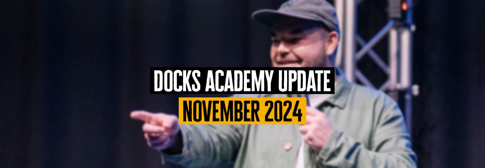 a graphic with a comedian on stage as the background and text reading 'docks academy update november 2024'