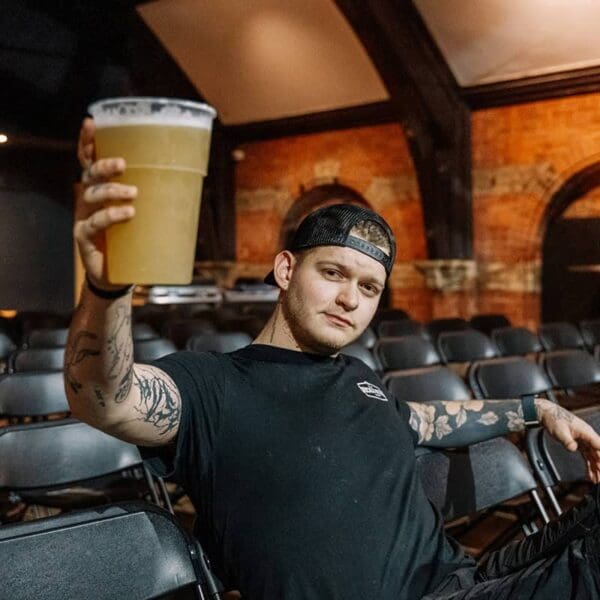 Photograph of a brewer holding a 2 pint cup